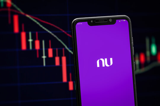 Cali, Colombia - January 12 2026: Nubank logo on the smartphone screen and the chart of bear stock market at the blurred background.