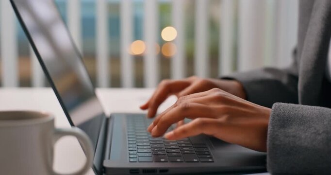Business woman typing on laptop keyboard at office desk during professional work.