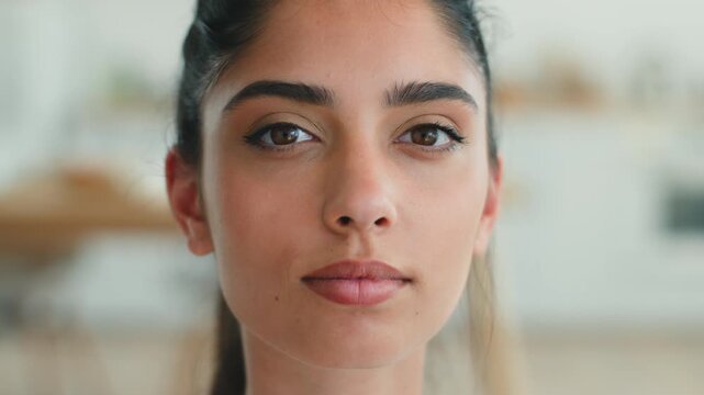 Pretty Indian woman looking down then at camera home apartment calm face thinking ethnic businesswoman headshot relaxed serious business female girl health loan mortgage credit bank indoors lifestyle