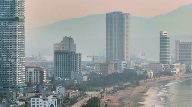 A panoramic view of the coastal city of Quy Nhon, Binh Dinh, Vietnam, showcasing its modern skyscrapers and bustling beach. The city is a popular tourist destination.