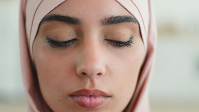 Close up sad upset Arabian Indian Muslim woman at home wearing hijab looking down pensive stressed sadness disappointed frustrated female Islamic girl reflecting grief thinking discrimination indoors