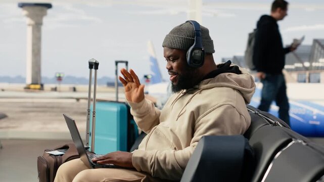Digital nomad participating in online video call in airport terminal lounge, virtual meeting with client while waiting for flight departure. Telecommuting and work anywhere nomadic lifestyle.