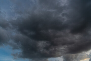 Fototapeta premium Dark thunderstorm clouds rainny season. Meteorology danger windstorm disasters climate. Banner Dramatic dark storm clouds black sky background. Dark thunderstorm clouds rainny atmosphere.