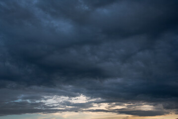 Obraz premium Dark thunderstorm clouds rainny season. Meteorology danger windstorm disasters climate. Banner Dramatic dark storm clouds black sky background. Dark thunderstorm clouds rainny atmosphere.