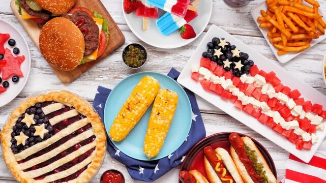 Fourth of July, patriotic, American themed food. Slow rotating zoom motion. Top view table scene on a white wood background.