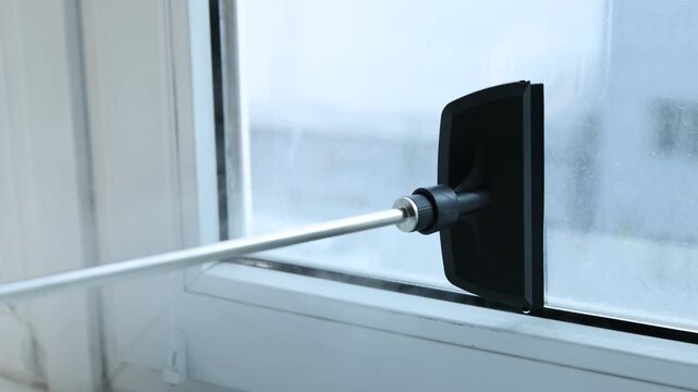 Cleaning window with steam cleaner at home, closeup. Camera moving left