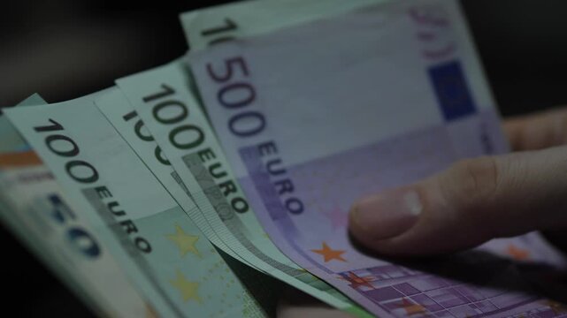 Close up of male hands counting various Euro banknotes of different denominations. Concept of European economy, currency exchange and personal finance management