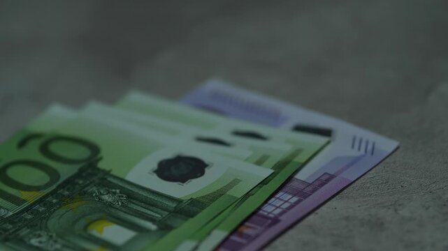 Euro banknotes of different denominations falling on surface creating a stack of cash. Concept of capital accumulation, European economy and personal wealth growth