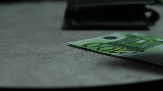 Colorful Euro banknotes falling on top of each other near a wallet on a gray table. Concept of financial turnover, cash savings and European Union economy
