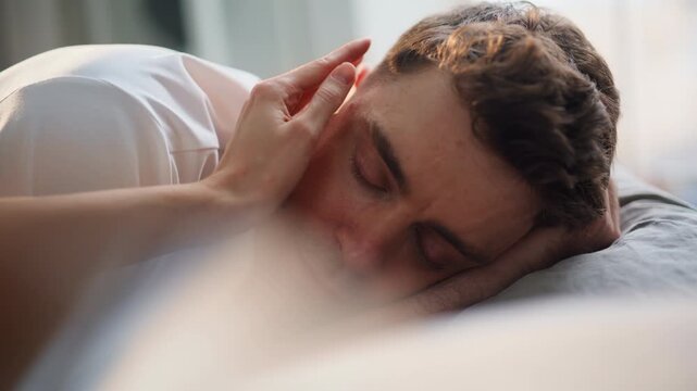 Lady fingers touching boyfriend face morning closeup. Enamoured man opening eyes