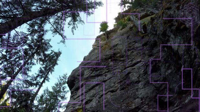 Climber pulling, to reach top while ascending rock face as camera tilting up, purple HUD expanding