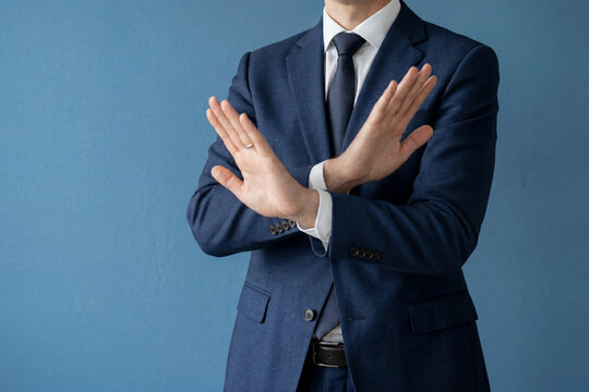スーツ男性が両手で拒否を示すポーズ