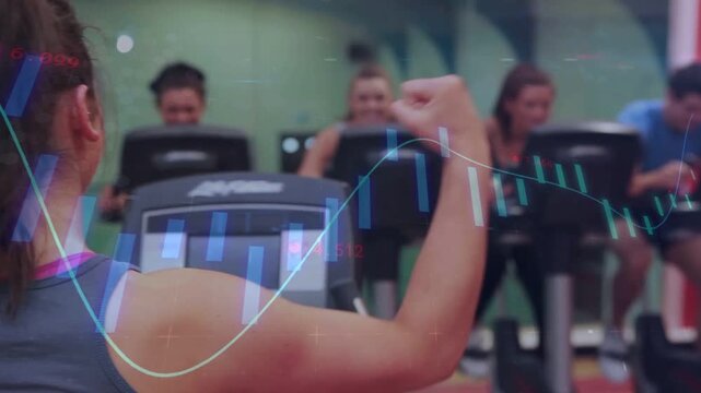Woman pedaling on bike, raising fist while pedal motion driving animated data overlay for fitness