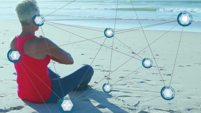 Senior woman adjusting pose on beach camera panning causing health hex overlay growing for wellness