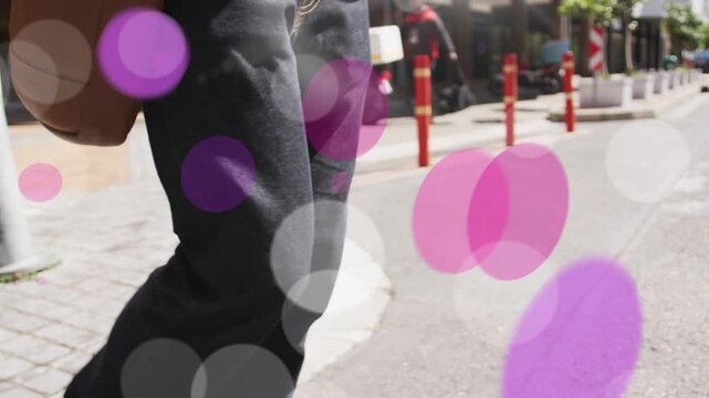 Man stepping off curb, commuting on street, adjusting satchel while bokeh overlays circling phone