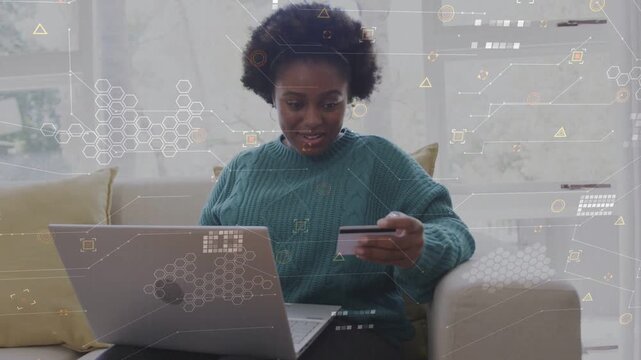 Adult woman typing on laptop holding card on sofa, showing finance HUD confirming order