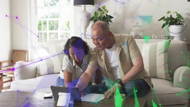 Couple leaning, starting consulting tablet and papers, marking finances under faint mesh overlay