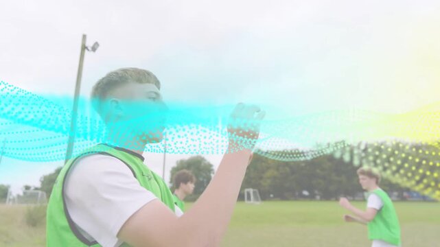 Front teen in green bib catching ball being tossed in sports while animated wave tracking passes