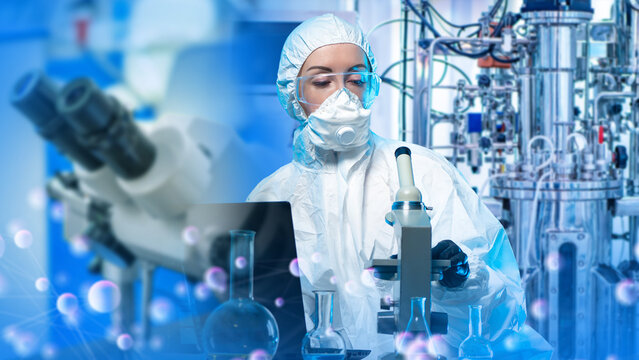 Pharmaceutical manufacturing, researcher in protective suit operates microscope and analyzes data, sterile lab testing, bioprocess development and quality control