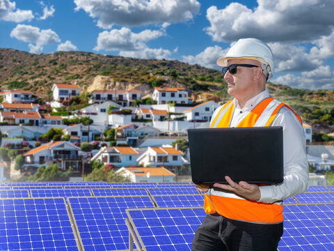 Renewable energy management, engineer inspects solar panels using laptop, monitors power generation, sustainable infrastructure and smart grid operations
