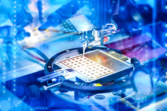 Microelectronics manufacturing, semiconductor production. Precision machine processes circuit wafers using automated system, ensuring accuracy in chip fabrication and high tech assembly.