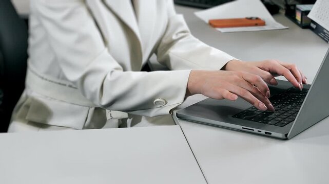 Close up of business woman typing on laptop at office desk modern workplace digital work and communication.