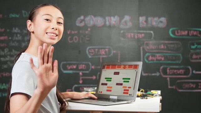 African boy wearing VR while caucasian girl using laptop and turn around to wave hand at camera. Adult standing at blackboard with code and prompt written while woman greeting at camera. Edification