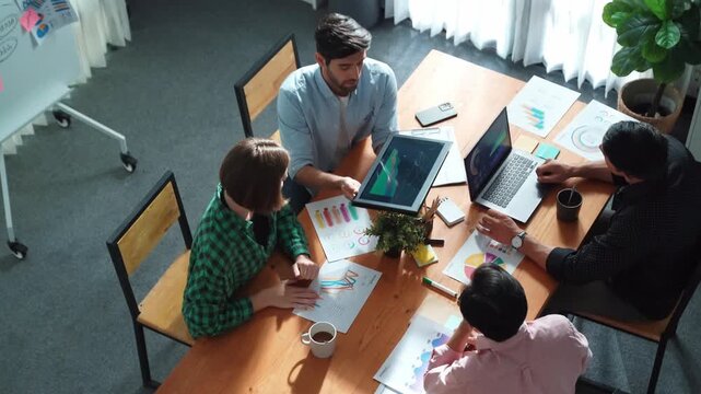 Top view of project manager present financial graph to investors at meeting. Professional marketing team brainstorming financial idea while looking at financial statistic from laptop. Convocation.