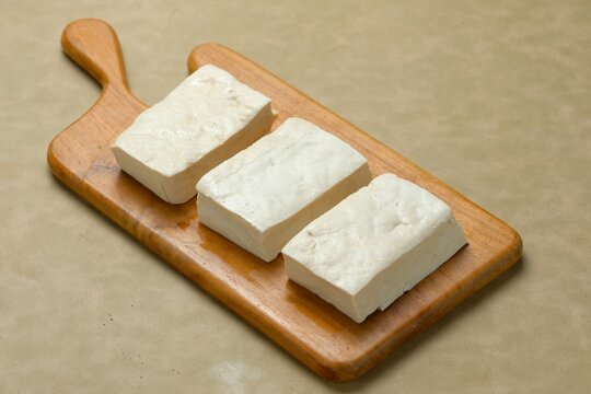 Raw tofu or tahu putih on wooden board before cut off. Preapare for cooking.