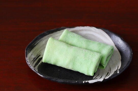 Close up shot of some homemade Indonesian coconut pancake "Dadar Gulung" on plate in natural light.
