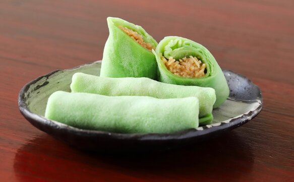Close up shot of some homemade Indonesian coconut pancake "Dadar Gulung" on plate in natural light.