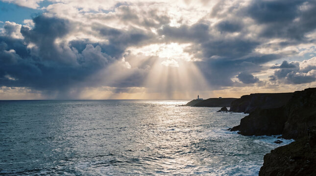 After the storm ocean horizon glows with shafts of sunlight textured silver clouds dramatic seascape