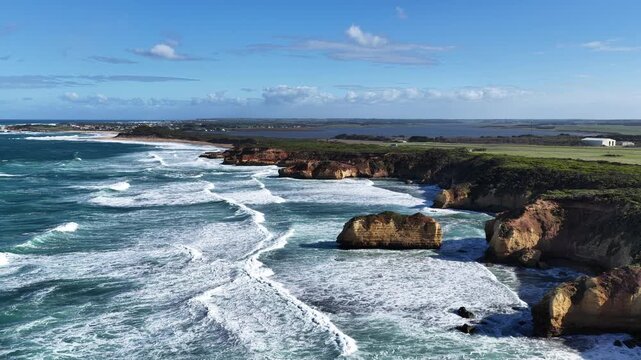 The Grotto Track, Great Ocean Road, Peterborough, Victoria, Australia: 4K aerial drone footage of limestone cliffs, ocean waves, blue sea, rock formations and rugged coastline. 