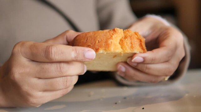 Close-up of Hands Breaking a Piece of Cake