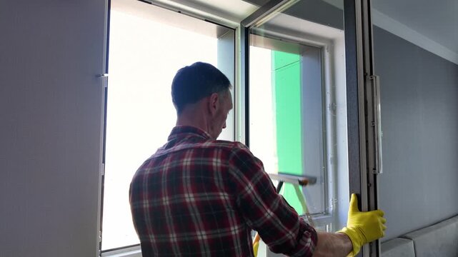 Professional window cleaner using squeegee on glass
