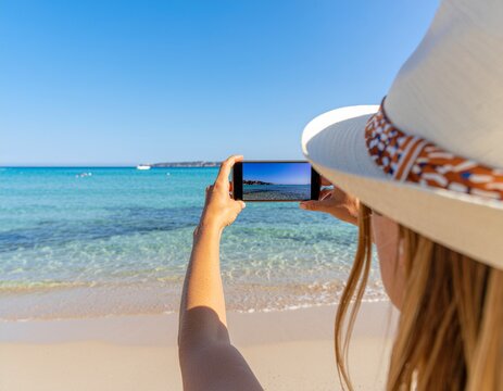 スマホで海を撮影する女性