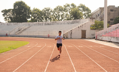 Fototapeta premium Focused athlete sprints on a track pushing limits in an empty stadium aiming for personal best