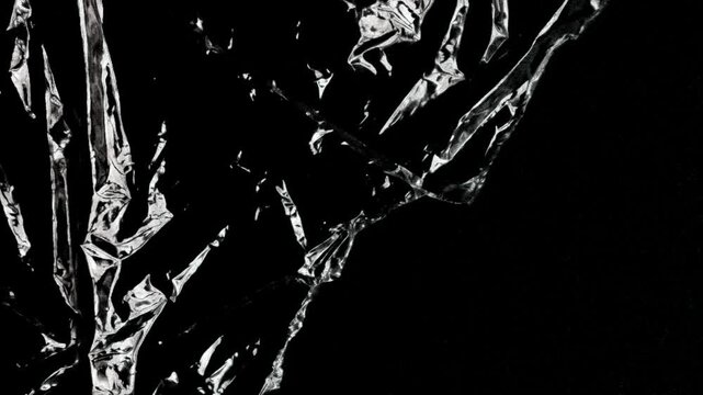 Abstract Crinkled Transparent Plastic Film Moving on Black Background
