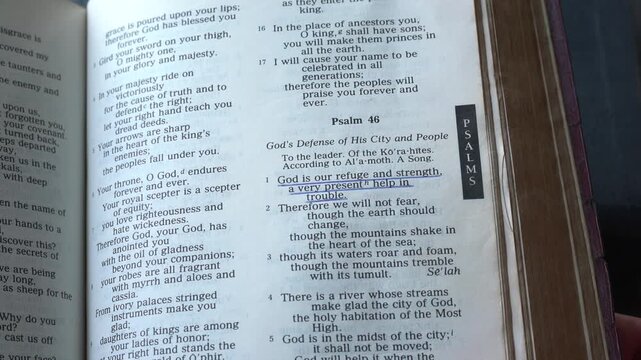 Opening the Book of Psalms of the Old Testament in the Holy Bible, zooming into Chapter 46 verse 1. New Revised Standard Version.