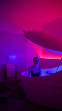Vertical. Woman finishes floatation therapy session in sensory deprivation pod