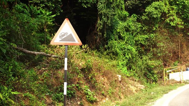 Road sign in the mountains says 'Steep grade ahead' or 'Uphill climb ahead'