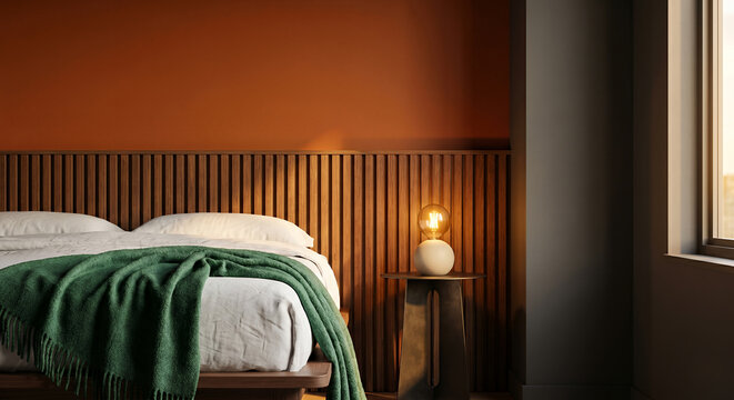 A modern bedroom with a bed, a green blanket, and a bedside lamp.