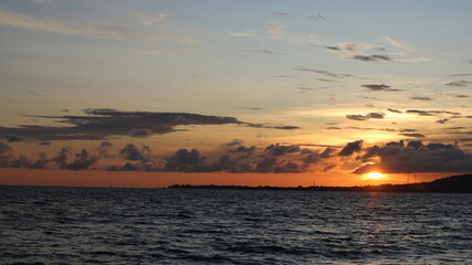 Obraz premium Sun sets over calm ocean waters