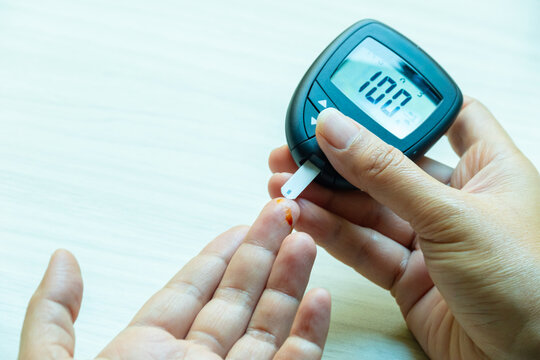 Woman's hands checking diabetes and hyperglycemia with digital blood sugar meter. Healthcare and medical concept	