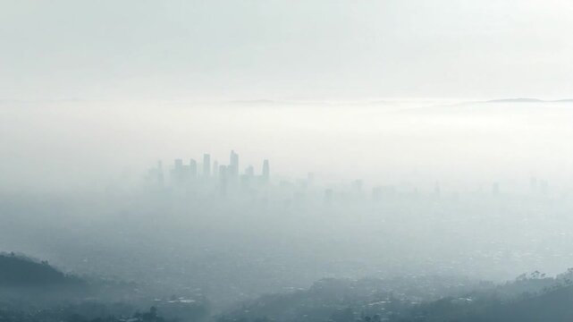 Cityscape Silhouette in Mist: A city's skyline emerges from a dense, ethereal mist, creating a captivating visual narrative of urban life, enveloped in an atmospheric haze. 