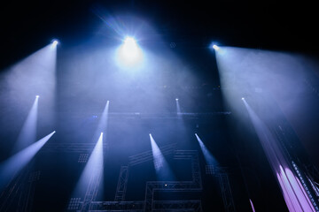 Stage lighting setup with multiple beams illuminating a dark performance area, creating a dramatic atmosphere for concerts or theatrical productions © Emvats