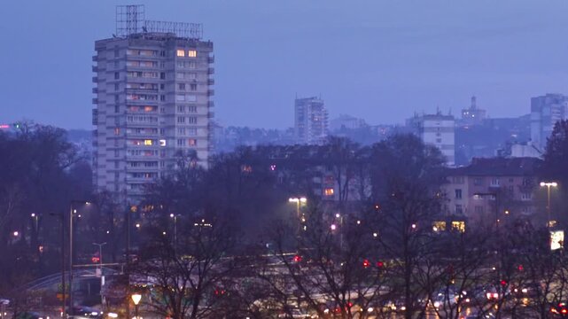 4K winter shot at dusk (evening) with beautiful pink and blue sky with trees, lights and the Vitosha mountain in the background in the city center of Sofia, Bulgaria in Eastern Europe.