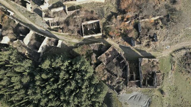 Drone view from above slowly flying over the ruins of the abandoned medieval village of Esco, revealing its desolate beauty and the surrounding arid landscape of Aragon, Spain