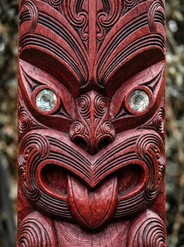 Traditional Māori carved wooden tiki with pāua shell eyes, New Zealand tribal art and cultural heritage close up. 