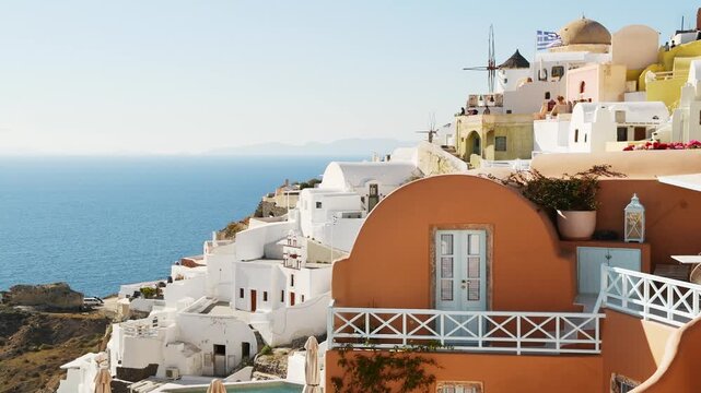Beautiful sunset at Santorini island, Greece. Colorful architecture and famous windmills in Oia town. Blue sea and the blue sky. Summer travel and vacation concept

